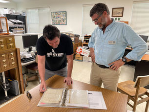Two people look at documents on a table