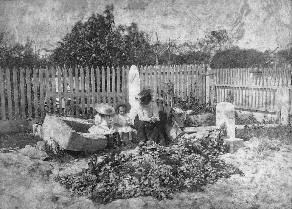 A group of people sitting on a gravestone in a cemetery