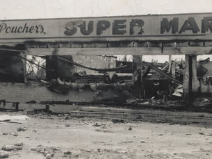 Burned out remains of a building a sign that reads Poucher's super market
