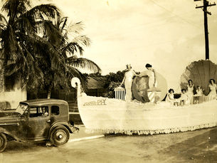 A 1920s style car pulling a flat