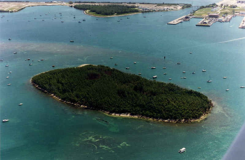 Aerial view of an island with boats moored around it.