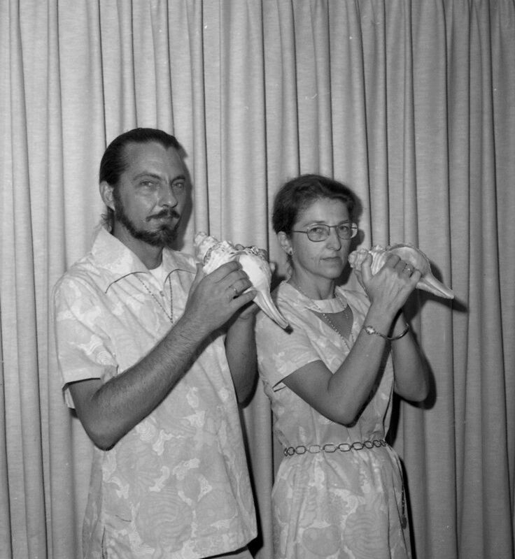 Two people holding conch shells