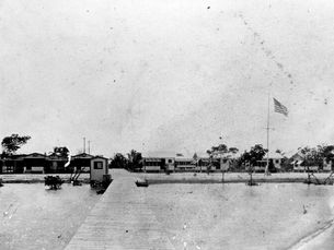 A shoreline with cottages and a pier, seen from the water