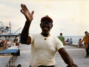 A man on a dock waves with one hand