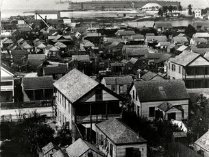 aerial view of a settled area with a fort and water in the background.