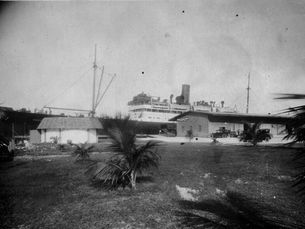 a ship at a pier with an upland area in the foreground.
