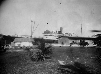 A ship at a pier with an upland area in the foreground.