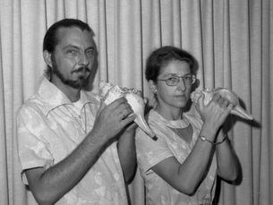 Two people holding conch shells