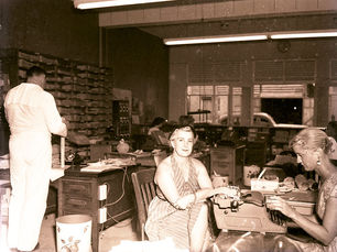 People in an office with a typewriter