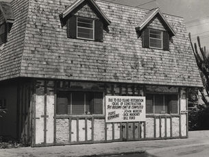 A building with a sign reading Due To Old Island Restoration Ideas of Construction this building can't be completed with three names listed as People Responsible.