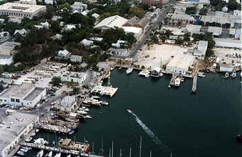 Aerial view of a marina and buildings on shore.