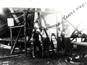a group of men stnading in front of a boat keel on scaffolding. Mr. James Weech is handwritten on the photo.