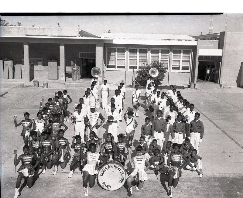 A marching band behind a bass drum labeled Douglass High School Band.