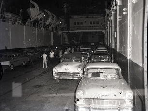 People and 1950s style cars in an enclosed space
