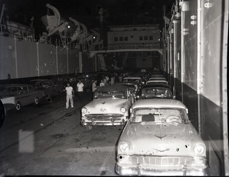 People and 1950s style cars in an enclosed space