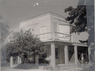 A two-story building with a Masonic symbol on the wall.