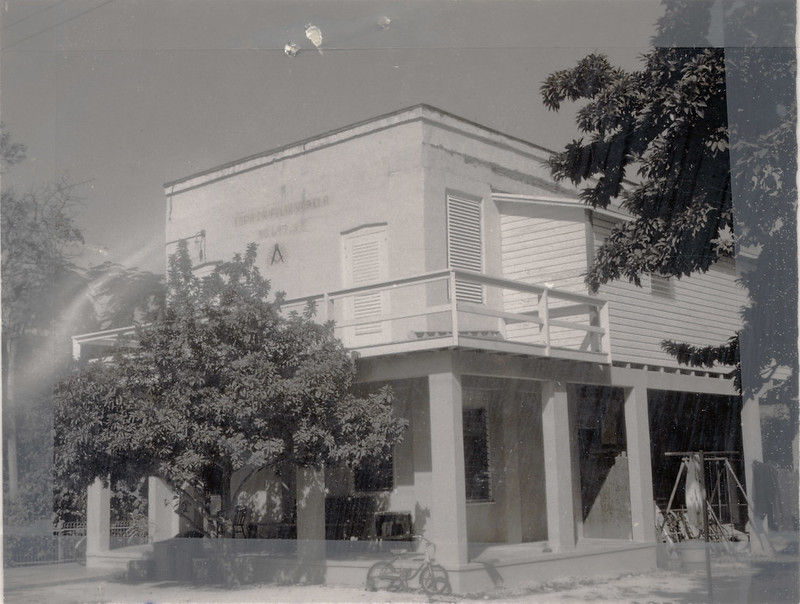 A two story building with a Masonic symbol on the wall.