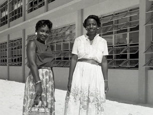 Two women standing in front of a two-story building