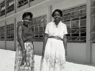 Two women standing in front of a two-story building