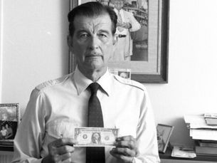 a man holding a $1 bill