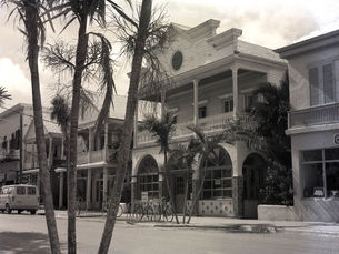A street with two story buildings both wood-frame and masonry.