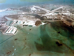 aerial view of a jet flying past an island with runways