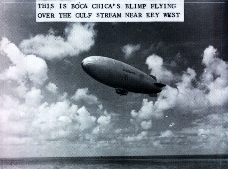 A blimp labeled US Navy over the water. Text on photo reads This is Boca Chica's blimp flying over the Gulf Stream near Key West.