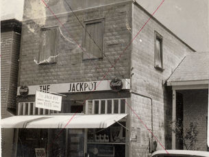 A store building with an awning and a sign on the front that reads The Jackpot.