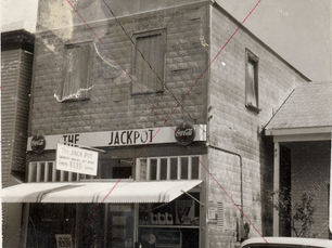 A store building with an awning and a sign on the front that reads The Jackpot.