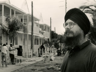 A man in the foreground with homes under construction in the background.
