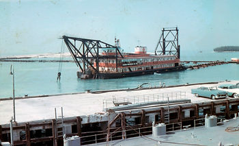 A dredge in the water, seen from a dock.