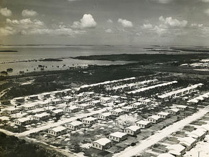 Aerial photo of rows of small buildings on a shoreline.