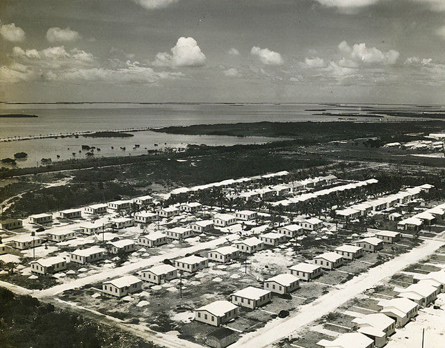 Aerial photo of rows of small buildings on a shoreline.