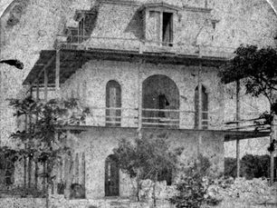 A three story building with a mansard roof and scaffolding on the second floor.