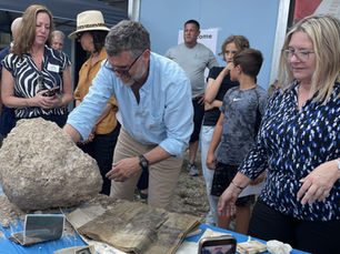 A man reaches into a concrete capsule while a woman watches