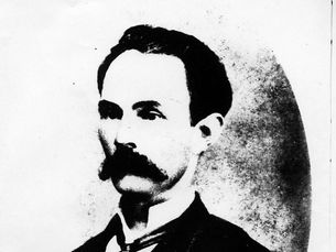 Black-and-white portrait of a man with a mustache in a suit, facing forward. 