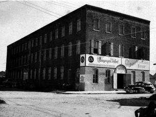 a three story brick building signs that read Champagne Velvet and Pabst Blue Ribbon Beer