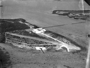 Aerial view of an island with some development and a road.