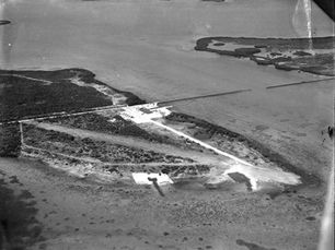 Aerial view of an island with some development and a road.