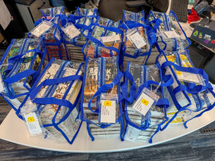A group of clear plastic bags with books inside.