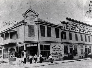 A group of people standing in front of a store with a sign that reads Garfunkel outfitter to men.