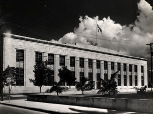 A large two-story stone building with signs on the front reading Post Office, Custom House and Court House.