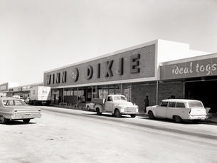 A shopping center with storefronts labeled Winn Dixie and ideal togs
