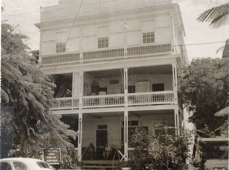 A three story woodframe building with porches on the first two floors.