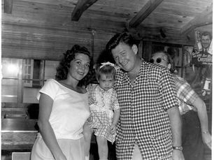 A woman and man hold a child between them.