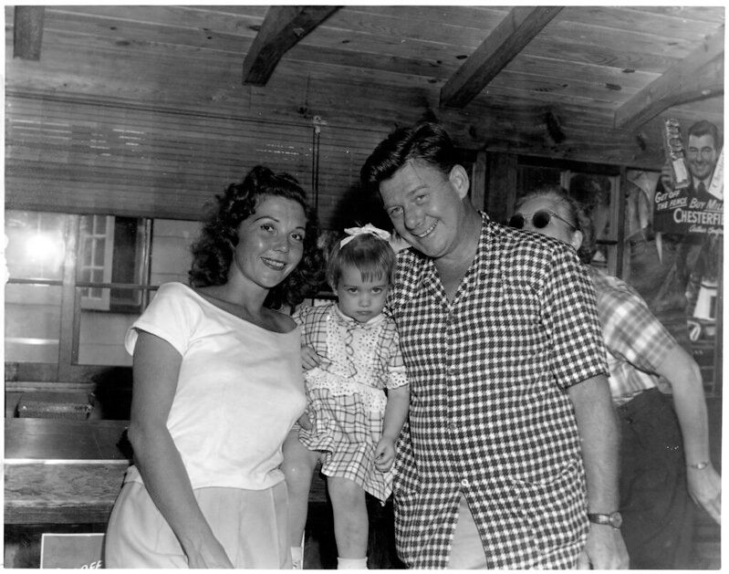 A woman and man hold a child between them.