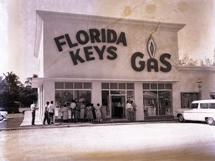 People in front of a building with Florida Keys Gas written on the side.