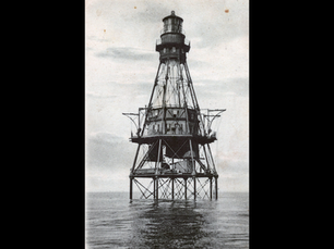 a lighthouse on the water with an enclosed structure halfway up