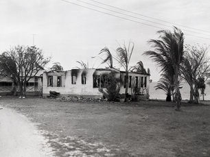 a burned out buildign with trees around it.