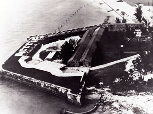Aerial view of a fort on a shoreline extending into the water.